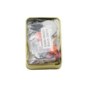 Gold tin containing fishing lures with a label on a white background