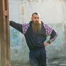 Man wearing a vintage 90s French military school sports jacket with retro striped shoulders and matching pants outdoors