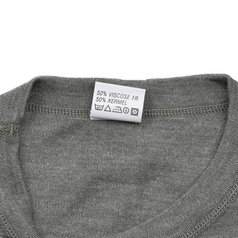 Close-up of gray Belgian military thermal flame-resistant undershirt showing fabric tag and round neckline stitching