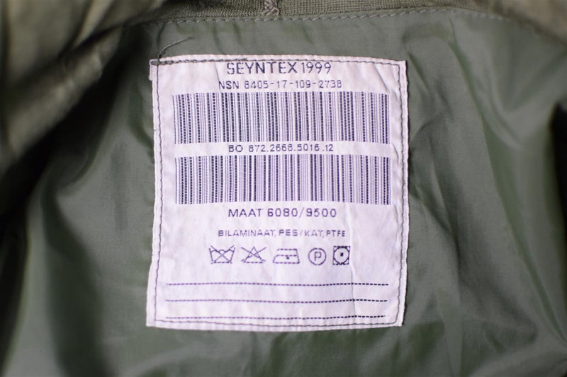 Close-up of a care label inside a Genuine Dutch Army waterproof bi-laminated combat parka in green fabric.