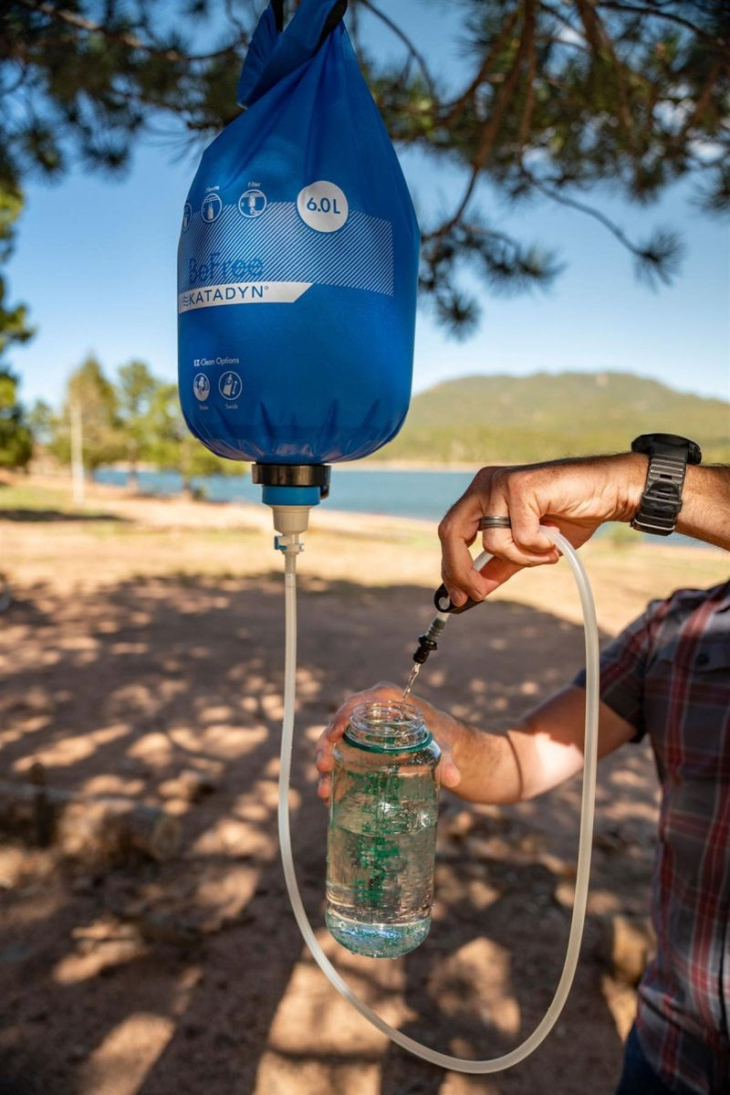 Katadyn BeFree Gravity 6L water filter hanging outdoors filtering clean water into a bottle on a hiking trip