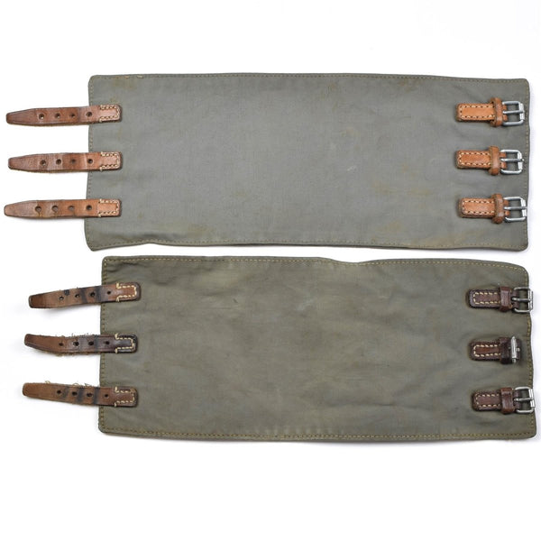 Pair of vintage Austrian Army M58 leg gaiters with leather straps and metal buckles in olive green military style