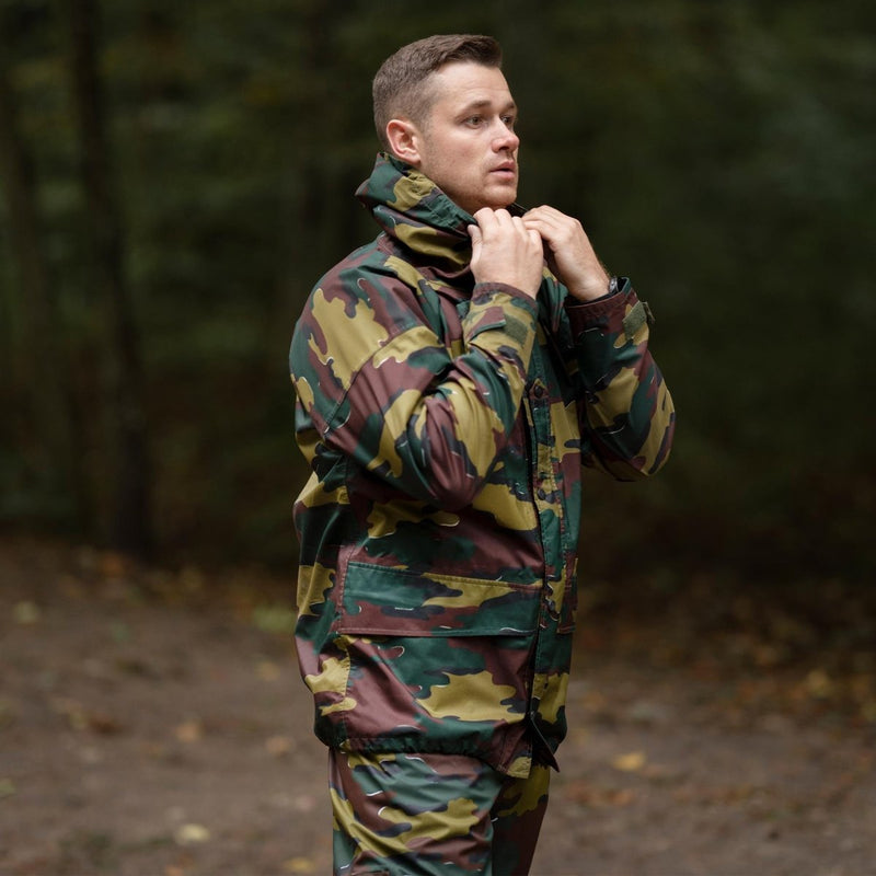 Man wearing original Belgian military waterproof jigsaw camouflage raincoat outdoors in forest setting