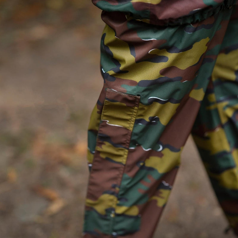 Close-up of waterproof Belgian military pants in jigsaw camouflage with reinforced knee and pocket detail outdoors