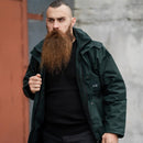 Man wearing original British police waterproof green anorak parka with hood and adjustable cuffs outdoors