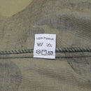 Clothing care label on Croatian woodland camo BDU shirt showing 100% cotton and washing instructions.