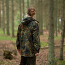 Person wearing original German army field jacket parka with flecktarn camo and hood in a forest setting