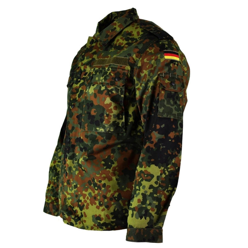 Original German Army shirt in flecktarn camouflage with zipped front, chest and arm pockets, and German flag patch on sleeve.