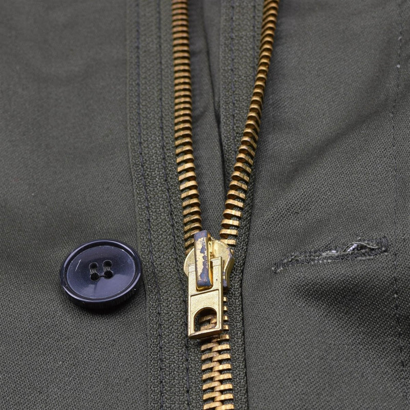 Close-up of olive green Greek military M65 field jacket zipper and button detail.