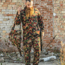 Man wearing Original Swiss army M83 Alpenflage camo combat jacket and pants holding matching bag and rifle outdoors