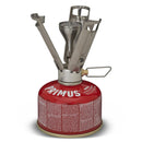 Primus Firestick Titanium lightweight camping stove mounted on red gas canister with unfolded pot supports.