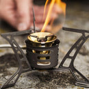 Primus OmniLite Ti titanium camping stove burner with flame, designed for lightweight, multi-fuel outdoor cooking.