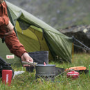 Primus PrimeTech 1.3L camping stove set with burner, pot, and ignition used outdoors by a tent.